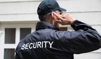 A security guard adjusts his ear plugs.